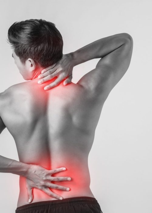 Close up of man rubbing his painful back isolated on white background.