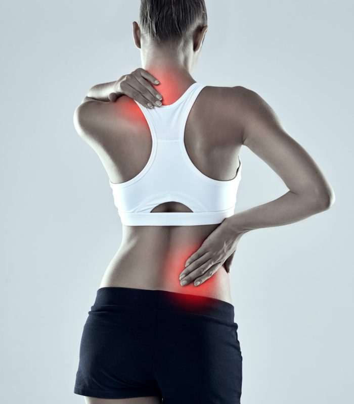Woman, athlete and neck or back pain in studio, inflammation and muscle sprain on gray background. Female person, runner and spinal injury from marathon or training, tender and ache or accident.